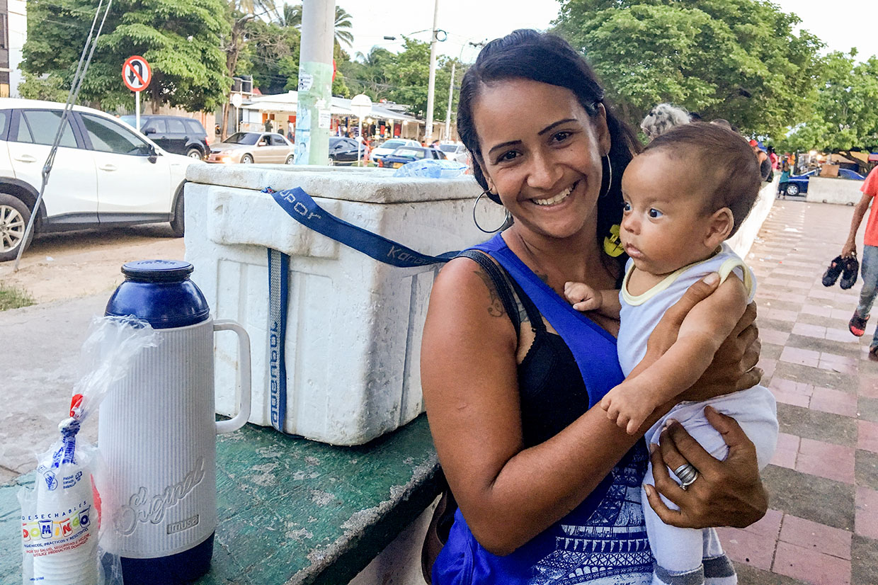 Elisa, a venezuelan migrant to colombia sells water and coffee in a park with her newborn child. photo: ana maria olarte/mercy corps