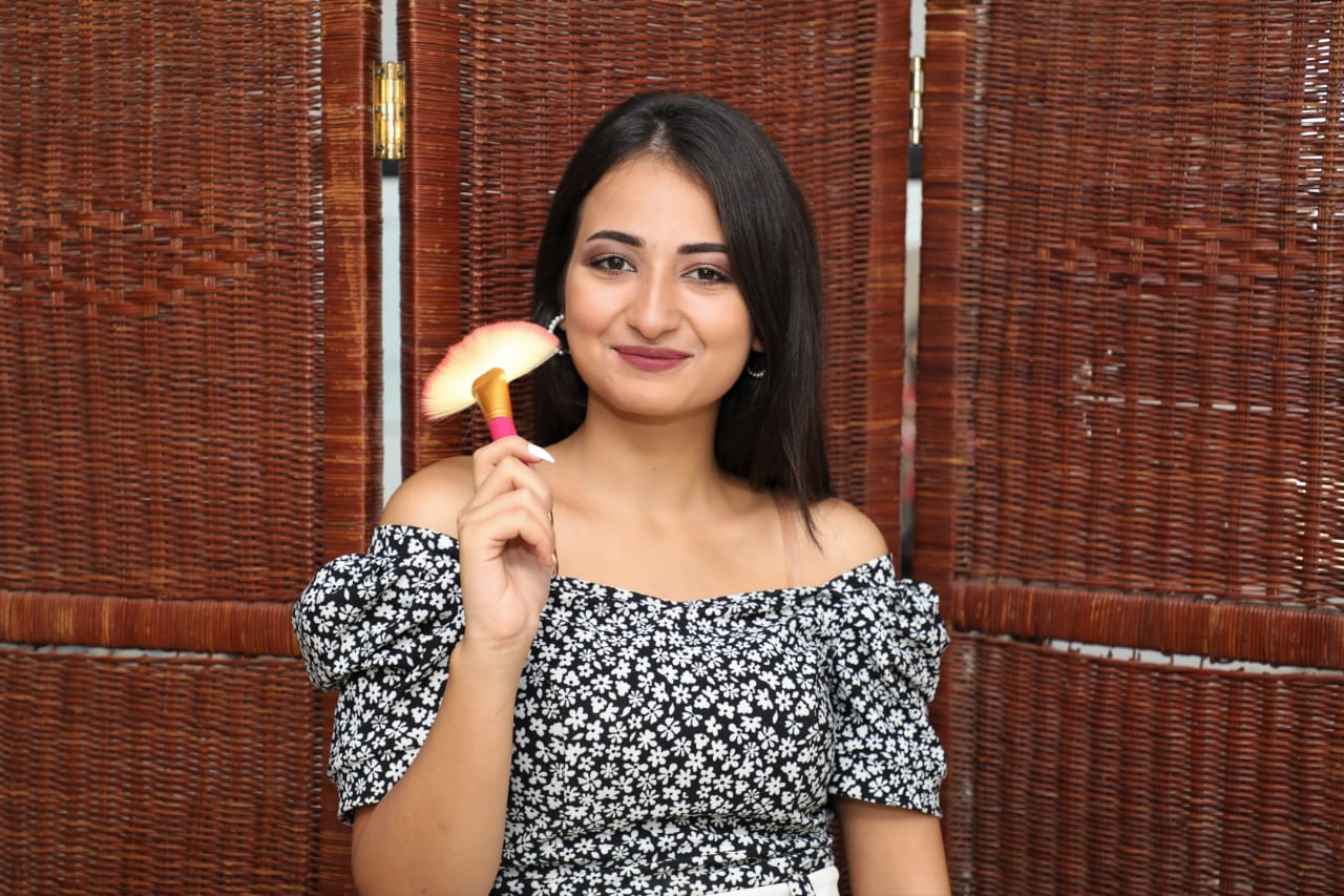 A person holding a makeup brush.