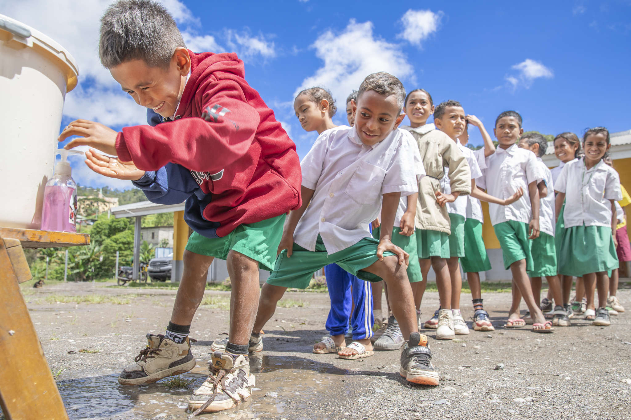 Children line up to wash their hands before eating lunch at school in maubisse villa, timor-leste.