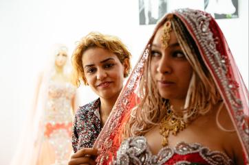 Olfa fitting a client's dress and veil