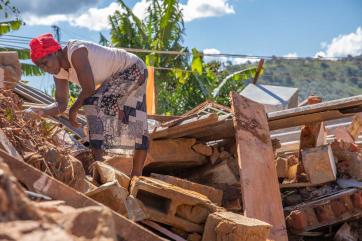 A woman looks through rubble in zimbabwe