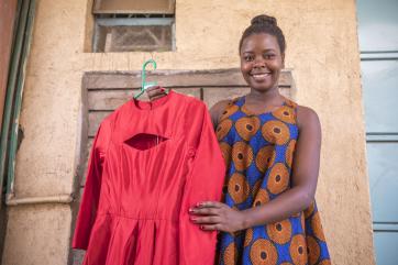 Keynan woman displays the clothing she's made.