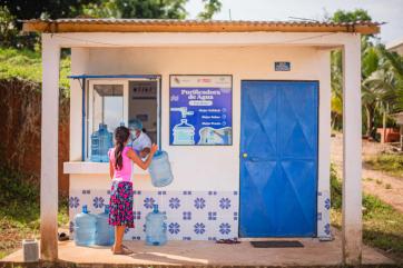 A person with water jugs at a water purification center.