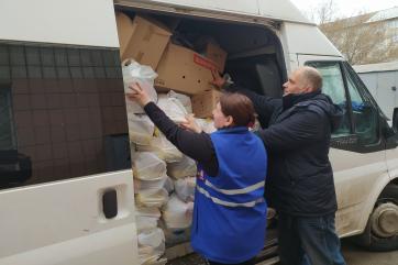 Two adults loading a van with supplies.