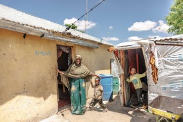 A family standing at the entrance to their house in sheder refugee camp in ethiopia.