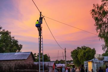 A technician climbs an electrical pole.