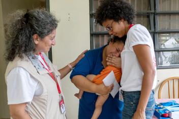 Stephanie Medina cries after Mercy Corps workers visit her for a distribution. With her home severely damaged, Medina has been staying with a friend for eight weeks with her 1-year-old son, Anthony, and her 2-year-old daughter, Kayla.