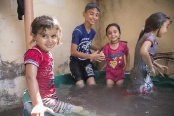 Rama, 3, cools off in an improvised pool made out of a plastic tub for kids to find relief in the sweltering heat. Summer temperatures in Mosul can climb as high as 117 degrees.