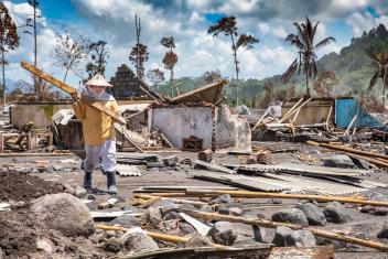 Lasiati salvages what she can find from her family’s home, after Mt. Semeru erupted in Indonesia. Mercy Corps responded by providing her and her neighbors with cooking supplies.