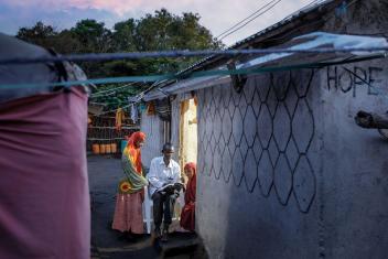 Farhan* takes two of his daughters through schoolwork. With support from Mercy Corps, Farhan connected his home to electricity in Ethiopia’s Sheder Refugee Camp. *Name has been changed